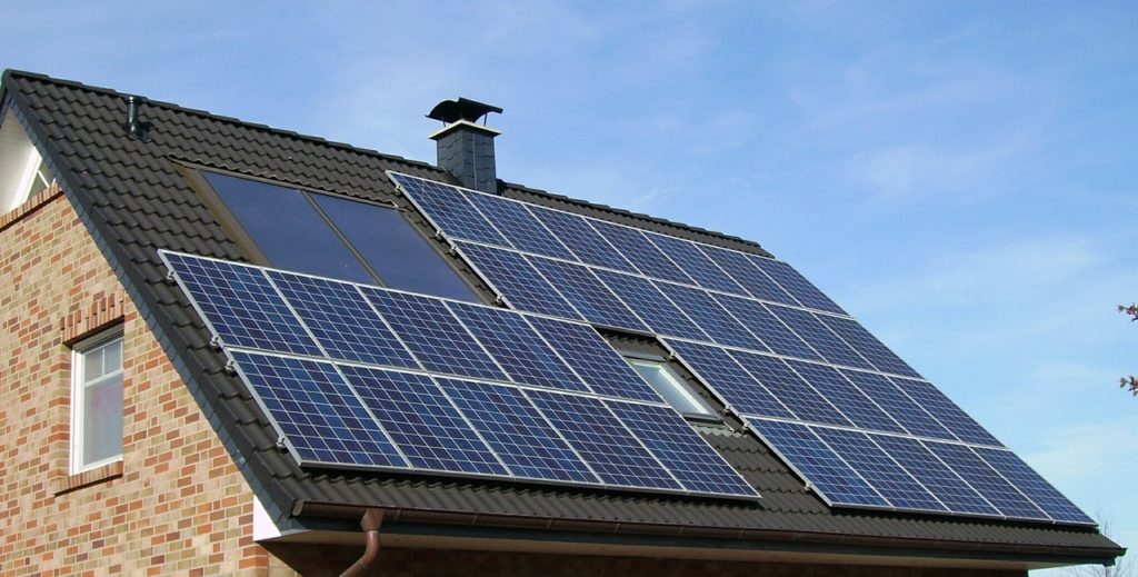 Imagem do telhado de uma casa com placas para a geração de energia solar instaladas.